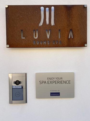 a sign on a wall with a camera and a box at LUVIA ROOMS SPA in Gonnesa