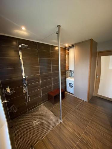La salle de bains est pourvue d'une douche avec une porte en verre. dans l'établissement Maison ossature bois, à Dole