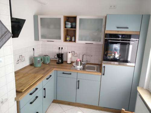 a small kitchen with white cabinets and a sink at Ferienhaus Eckernfeld Bremerhaven in Bremerhaven