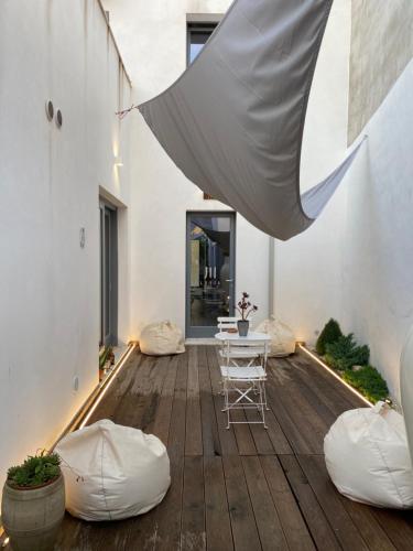 un patio con mesa y sillas en un suelo de madera en LUVIA ROOMS SPA en Gonnesa