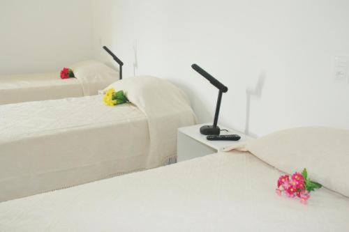 two white beds in a room with flowers on them at Clip d´Oro Hotel in Camaçari