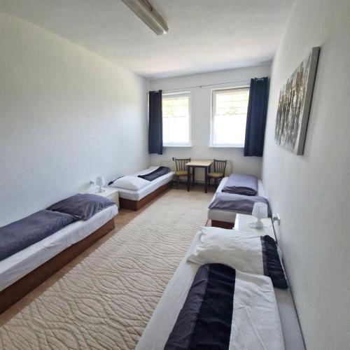 a room with three beds and a table at Ubytovanie KAMENICA in Štefanov