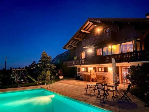 una casa con piscina por la noche en Cabane Jacomeli Genève, en Collonges-sous-Salève