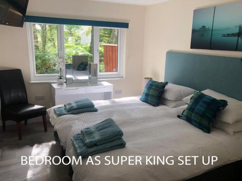 1 dormitorio con 1 cama con almohadas y silla en The South Cabin at Easter Arr, en Nairn