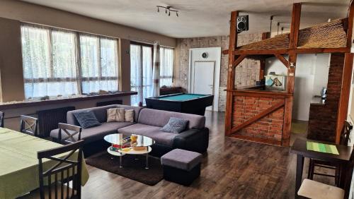 sala de estar con sofá y mesa de billar en Ubytovanie KAMENICA, 
