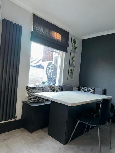 a kitchen with a table and chairs and a window at 3 Bedroom House on Beatles Famous Road in Liverpool