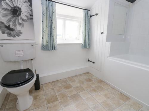 a bathroom with a toilet and a window and a tub at The LA'AL Cragg in Kirkby Stephen