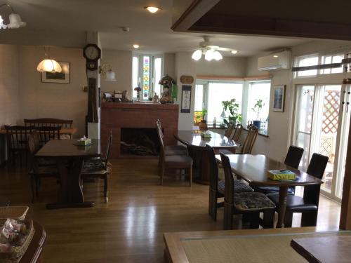 a dining room with tables and chairs and a fireplace at Natsumi no Sato in Biei