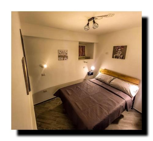 ein Schlafzimmer mit einem Bett in einem Zimmer in der Unterkunft 'Al Vico Dante' in Loceri