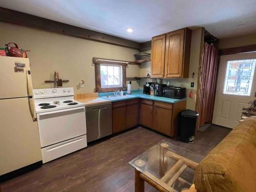 a kitchen with a white stove and a refrigerator at Deckers South Platte River Cabin 