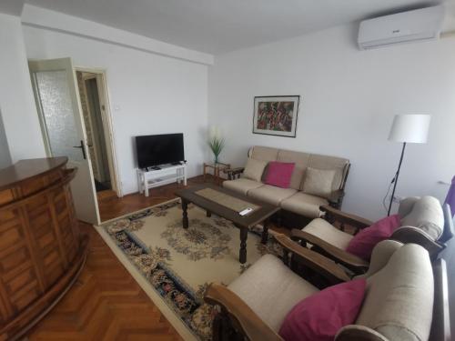 a living room with a couch and a tv at Apartman Monaco in Kraljevo