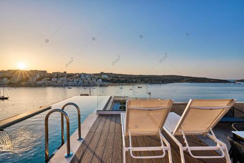 due sedie su una terrazza con vista sull'acqua di Lux Villa with Pool-Hosted by Sweetstay a San Pawl il-Baħar