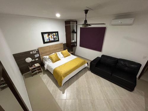 a bedroom with a bed and a black chair at Hotel La Casa 1 in Montería