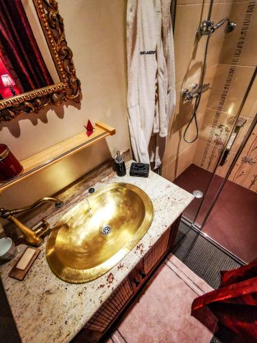 La salle de bains est pourvue d'un lavabo en or et d'une douche. dans l'établissement Villa Gontaud, à Gontaud-de-Nogaret