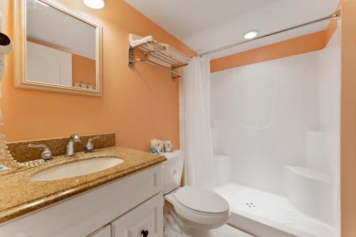 uma casa de banho com um lavatório, um WC e um espelho. em Nw Condo W Ocean View, Sundeck, Pool em North Wildwood