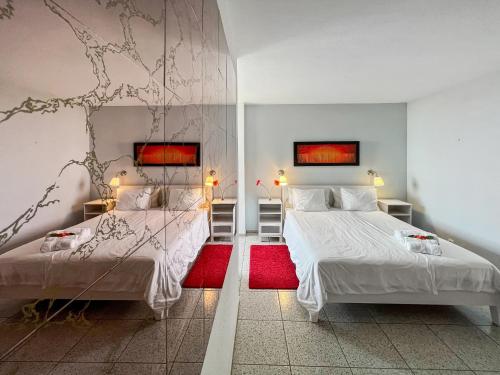 プエルト・デ・ラ・クルスにあるLarge Penthouse with Sunny Terraceのベッドルーム1室(ベッド2台、赤い敷物付)