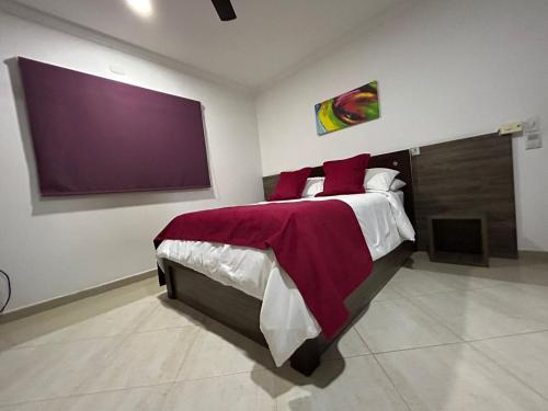 a bedroom with a large bed and a large screen at Hotel La Casa 1 in Montería