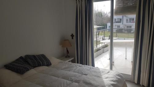 1 dormitorio con cama y ventana grande en Depto buena vista a espacio verde quincho y pileta en Rosario