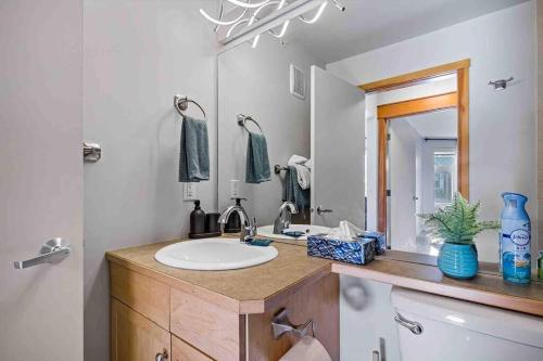 uma casa de banho com um lavatório e um espelho em Lux 2BR 5BD Suite Mountain view! em Canmore