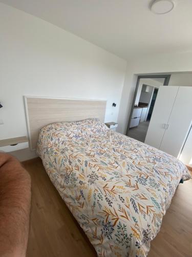 een bed in een kamer met een deken erop bij Appartement 21 in La Roche-Posay