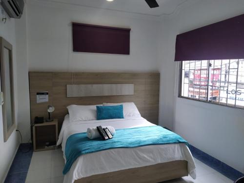 a bedroom with a bed with a tv on the wall at Hotel La Casa 1 in Montería