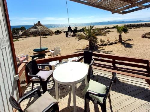 un patio con mesa y sillas en la playa en Cabañas Paraiso, en Bahía Inglesa