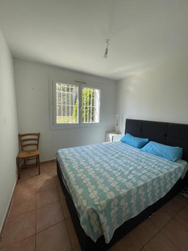 um quarto com uma cama com almofadas azuis e uma cadeira em Appartement de caractère vue mer panoramique em Bandol