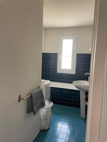 uma casa de banho com um lavatório, uma banheira e um WC. em Appartement de caractère vue mer panoramique em Bandol