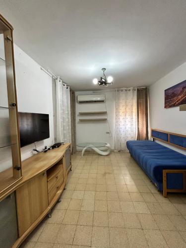 um quarto com uma cama e uma televisão de ecrã plano em 3-х комнатная квартира у моря в Хайфе em Haifa