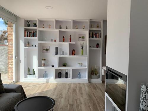 a living room with white shelves with plants on them at Lovely house near the beach in Calafell