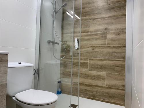 a bathroom with a toilet and a glass shower at Lovely house near the beach in Calafell