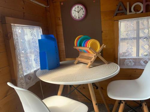 a table and chairs in a room with a clock at Lovely house near the beach in Calafell