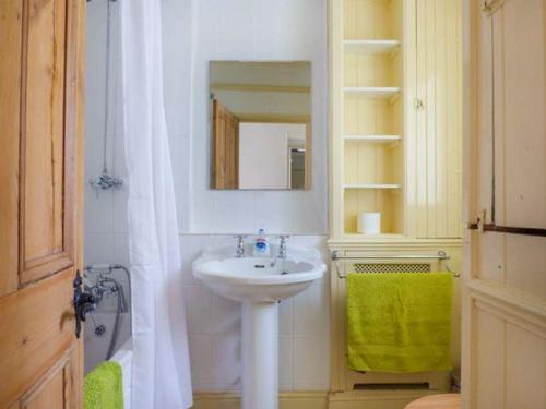 ein weißes Badezimmer mit einem Waschbecken und einem Spiegel in der Unterkunft The Green in Lastingham