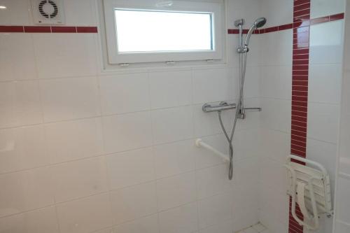 La salle de bains est pourvue d'une douche et d'une fenêtre. dans l'établissement T2 calme aux portes de Brest, à Bohars