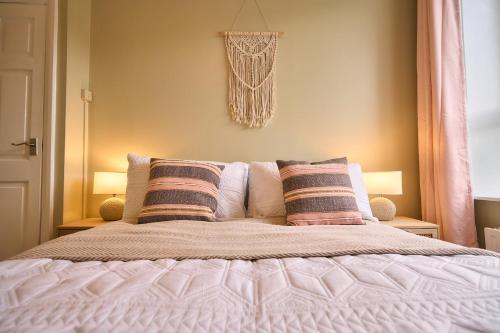 a bedroom with a bed with two pillows on it at Wood End View - Traditional Top-and-Bottom House in Hebden Bridge