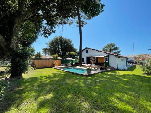 a backyard with a pool and a house at Villa Manita in Capbreton