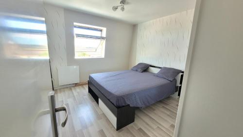 ein kleines Schlafzimmer mit einem Bett und einem Fenster in der Unterkunft Cosy Home Paris in Carrières-sous-Poissy