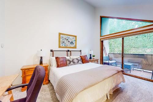 a bedroom with a bed and a desk and a window at King's Crown in Breckenridge