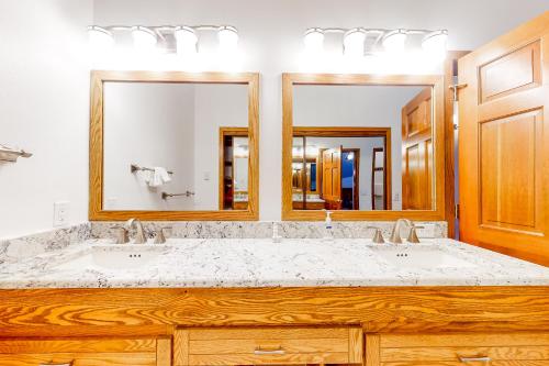 a bathroom with two sinks and two mirrors at King's Crown in Breckenridge
