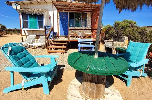 two chairs and a table in front of a house at Cabañas Paraiso in Bahia Inglesa