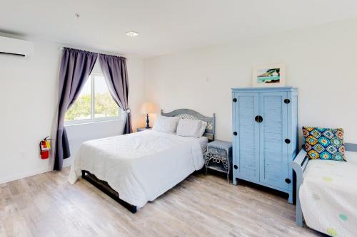 a bedroom with a bed and a blue cabinet at Ocean Isles #119 in Marathon