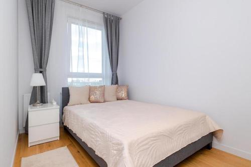 biała sypialnia z łóżkiem i oknem w obiekcie Apart D&K Free Parking Komputerowa 8 w Warszawie