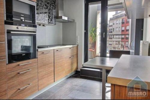 cocina con armarios de madera y horno con fogones en Spacious 2 bedrooms in City Center with Terrace-9, en Luxemburgo