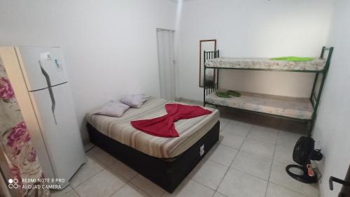 een kleine slaapkamer met een bed met een rood shirt erop bij Casa Del Mar in Cabo Frio