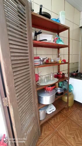 een keuken met planken gevuld met potten en pannen bij Casa Del Mar in Cabo Frio