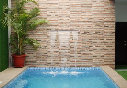 a swimming pool in front of a brick wall at Casa Dome in Santa Elena