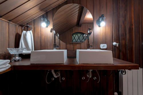 a bathroom with two sinks and a mirror at Alma Hotel in Campos do Jordão