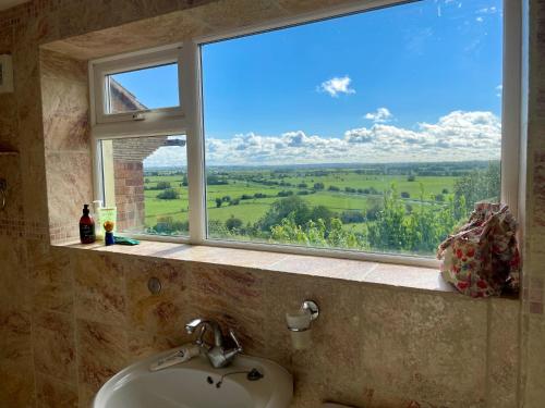 a bathroom sink with a window with a view at Magic of Avalon in Glastonbury