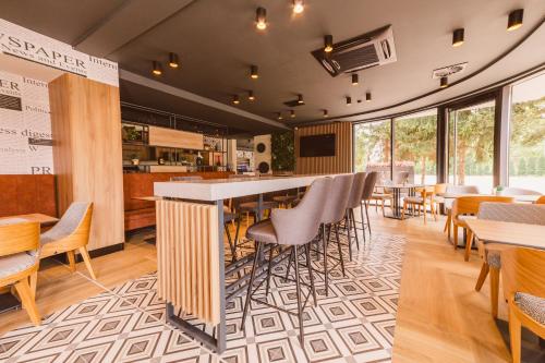 a restaurant with a bar and tables and chairs at Hotel Boutique Anoma in Sarajevo