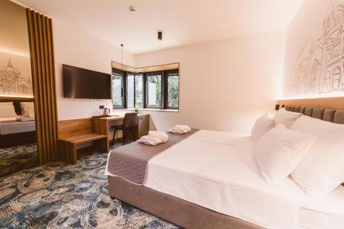 a hotel room with a bed and a desk at Hotel Boutique Anoma in Sarajevo